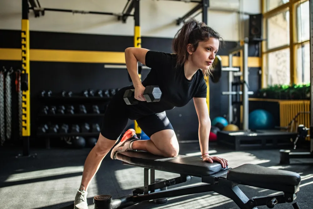A supported dumbbell row using a training bench